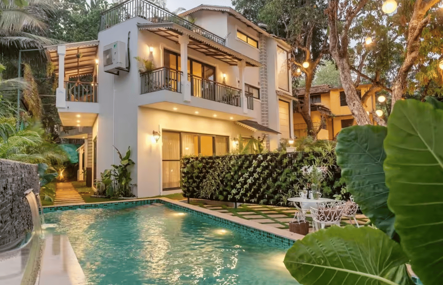 Exterior view of the villa with a pool surrounded by lush plants at Lime Tree Villa with Private Pool | Luxury Stay in Goa.